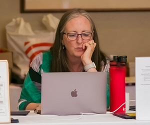 a woman sitting and using a laptop