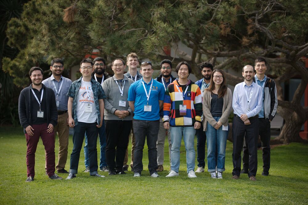 a group of young people posing for a photo outdoors