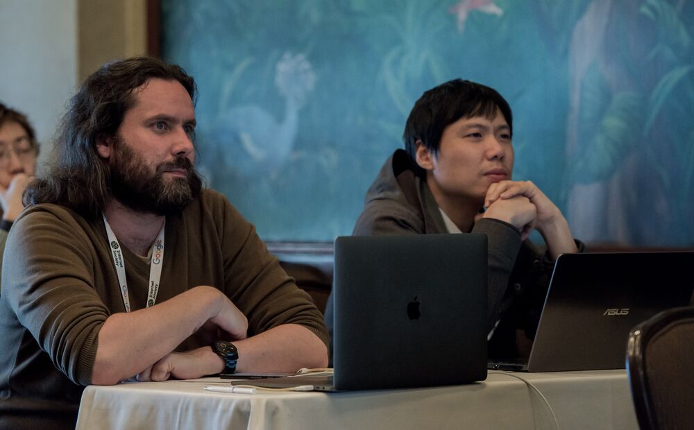 Two men sitting and listening at the workshop